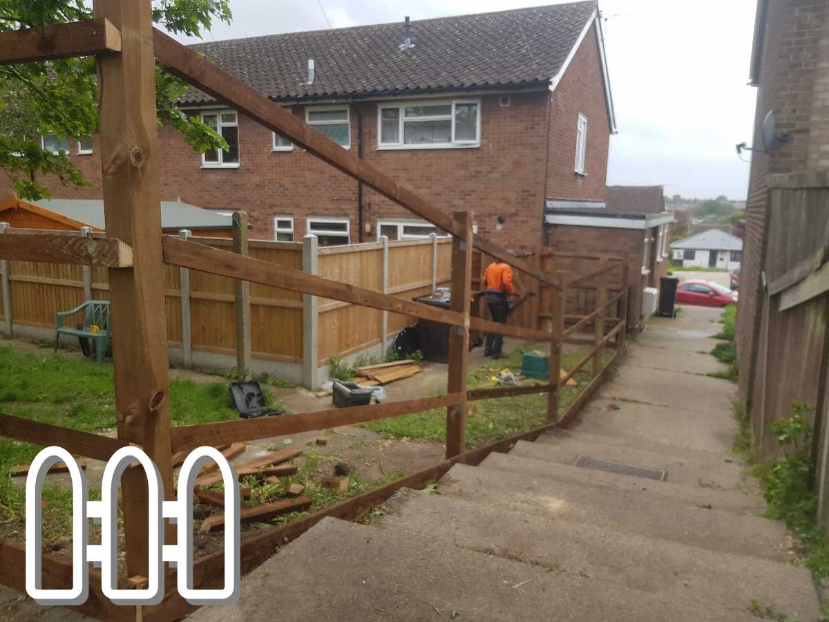 Worker installing a new wooden fence in a residential area