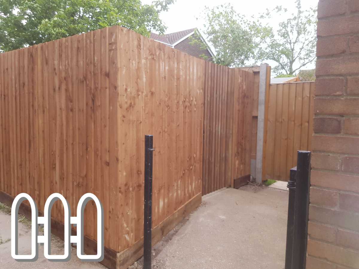 Sturdy wooden fence with vertical planks and black metal support poles installed on a residential property