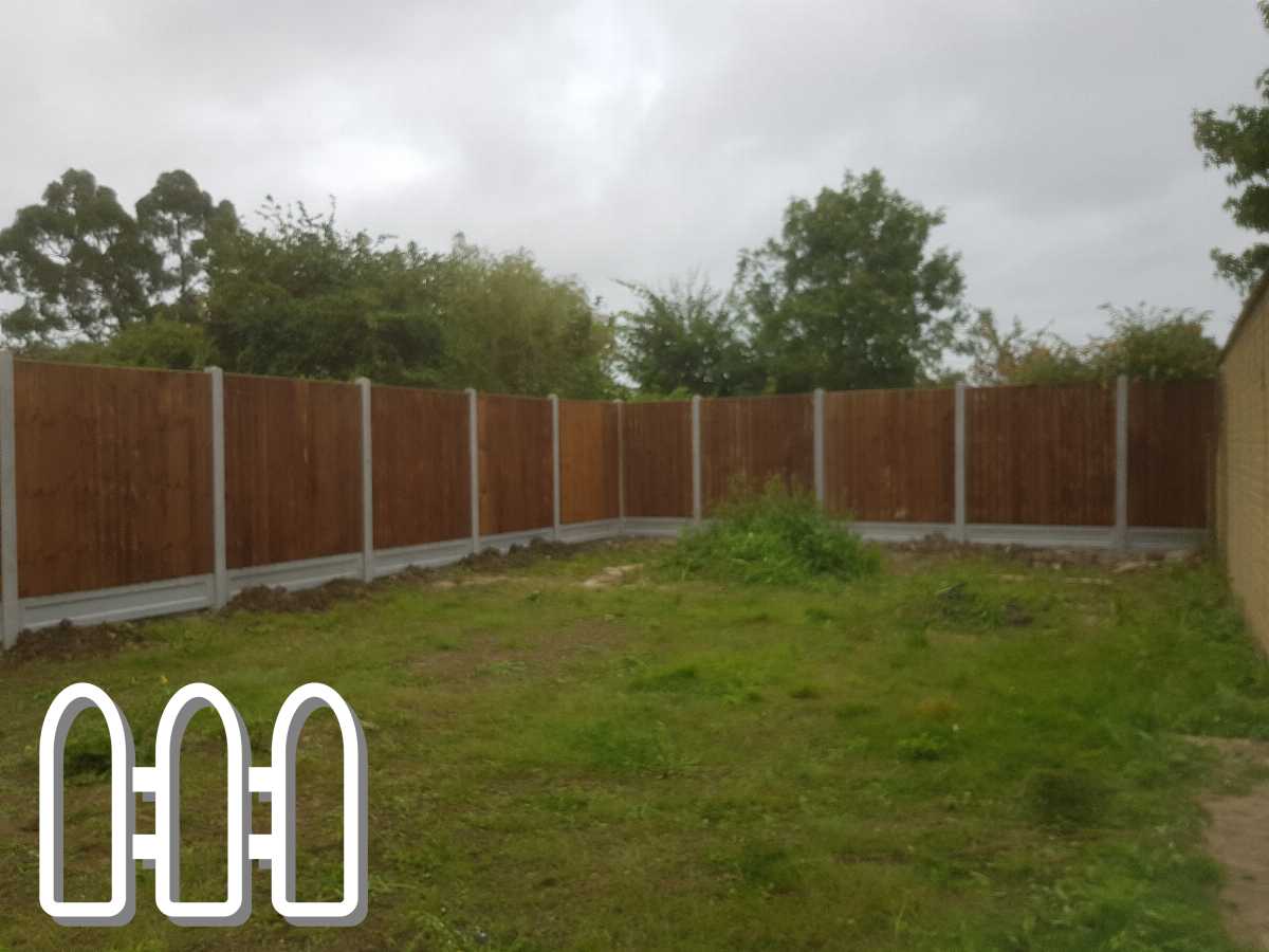 Newly installed wooden fence with concrete posts in a residential backyard on a cloudy day