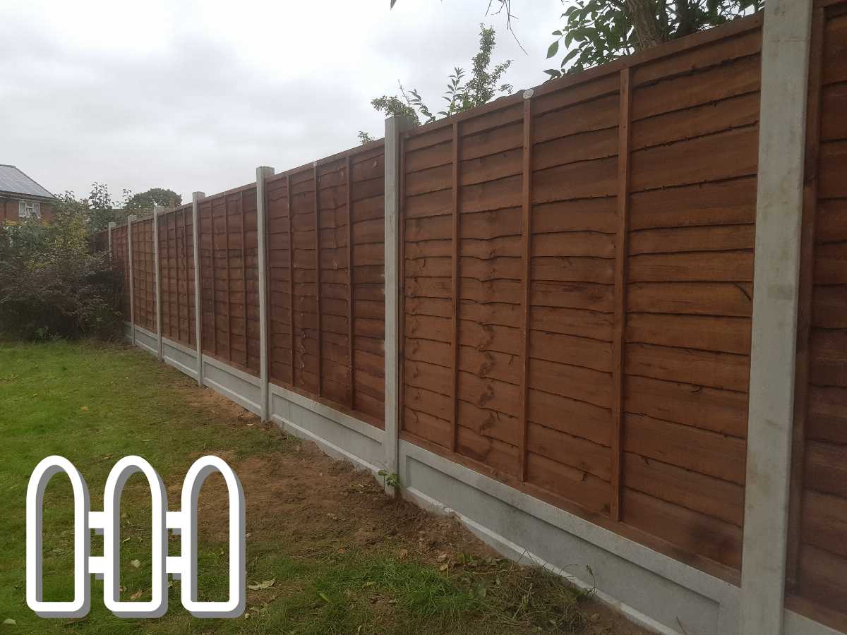Sturdy wooden garden fence with concrete posts and base panels on a grassy backyard