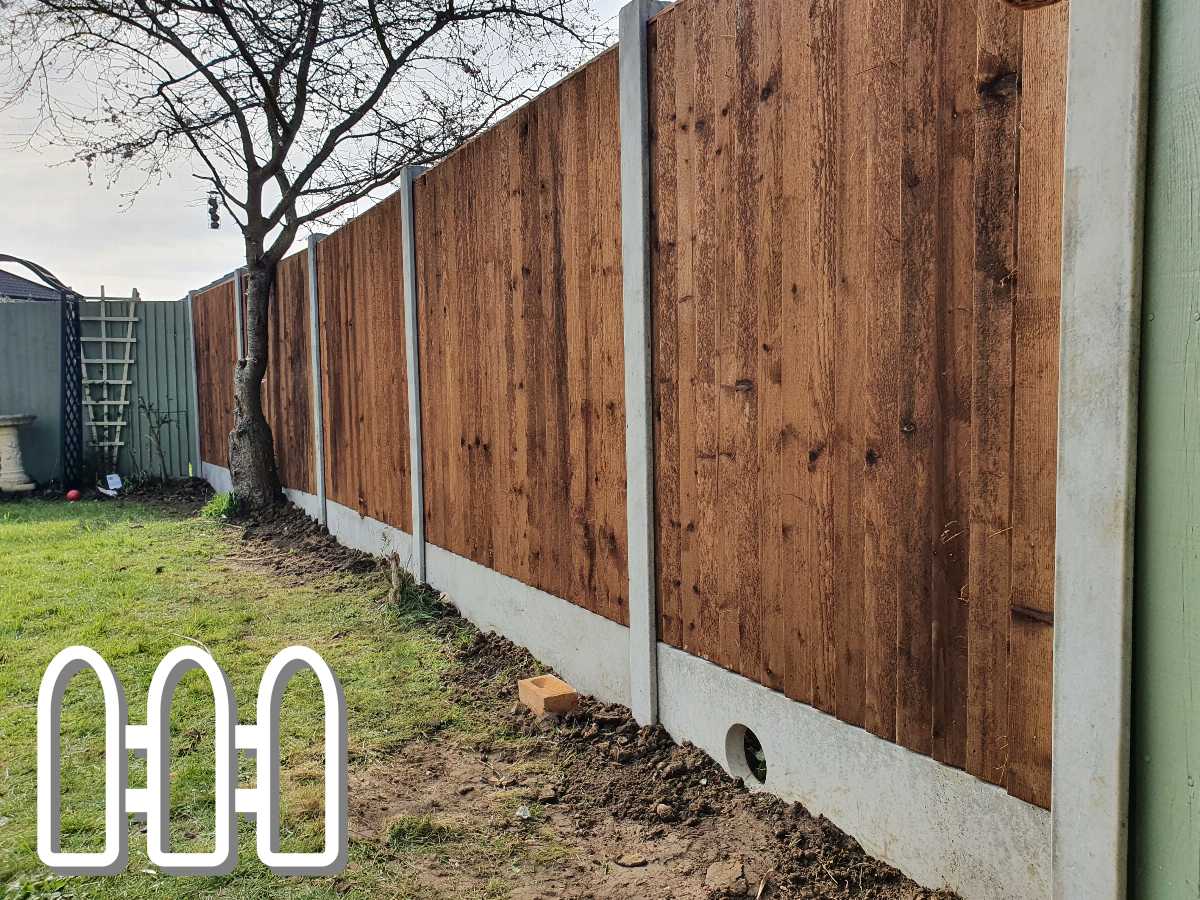 Sturdy wooden fence panels installed in a backyard, with a tree closely positioned to the fence line and green grass on the side