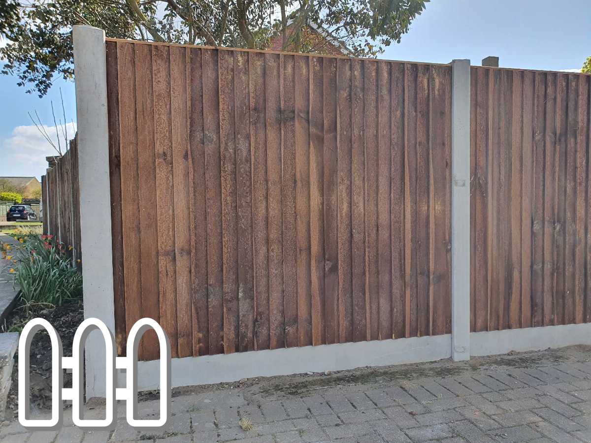 Durable wooden slat fence with vertical panels and white concrete posts, providing privacy and aesthetic appeal to a residential property.